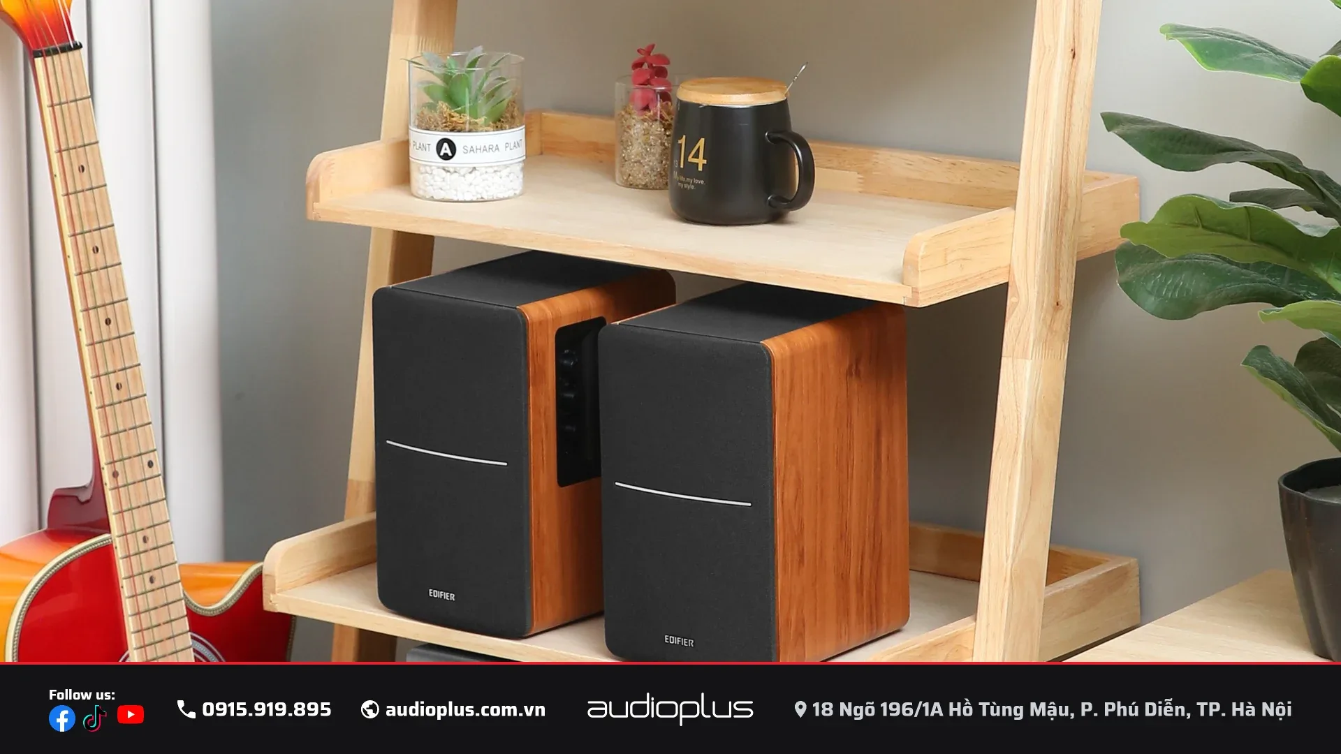 Loa EDIFIER R1280DBs trên kệ gỗ cạnh đàn guitar