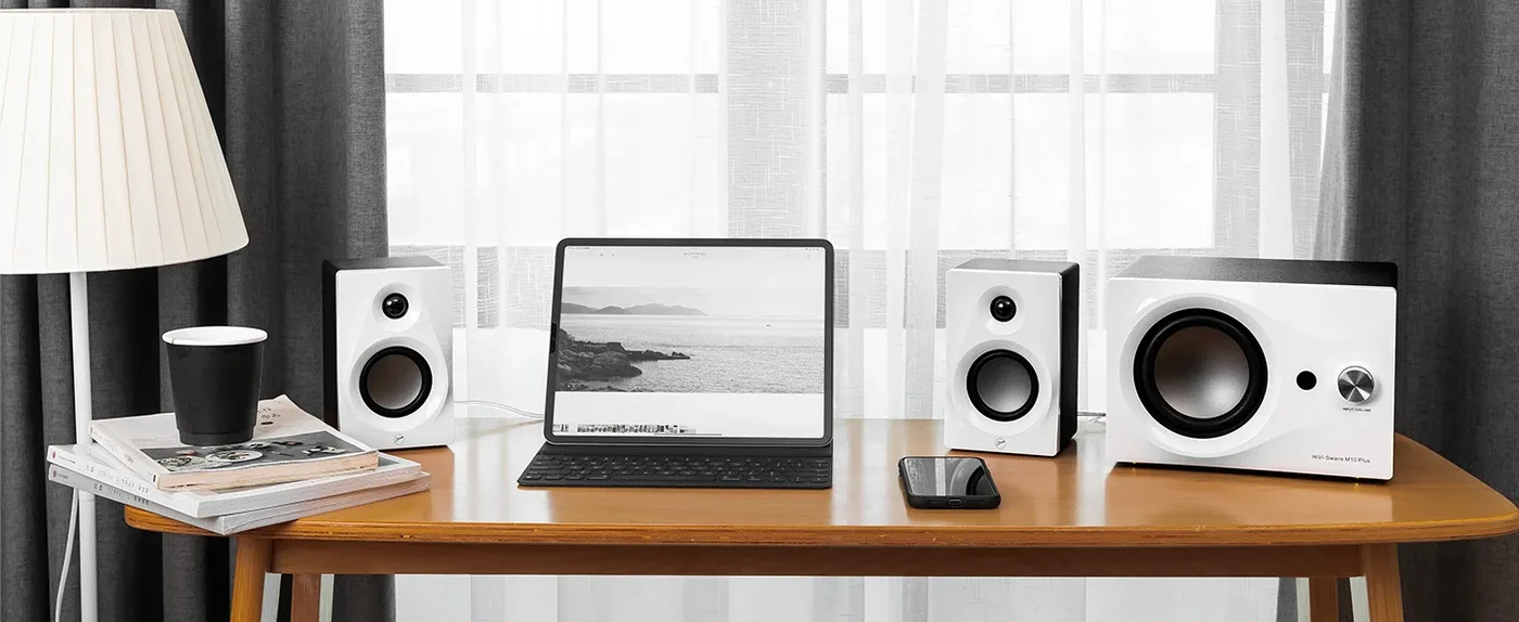 Loa máy tính SWAN M10 Plus đặt hai bên trên bàn làm việc bên cửa sổ